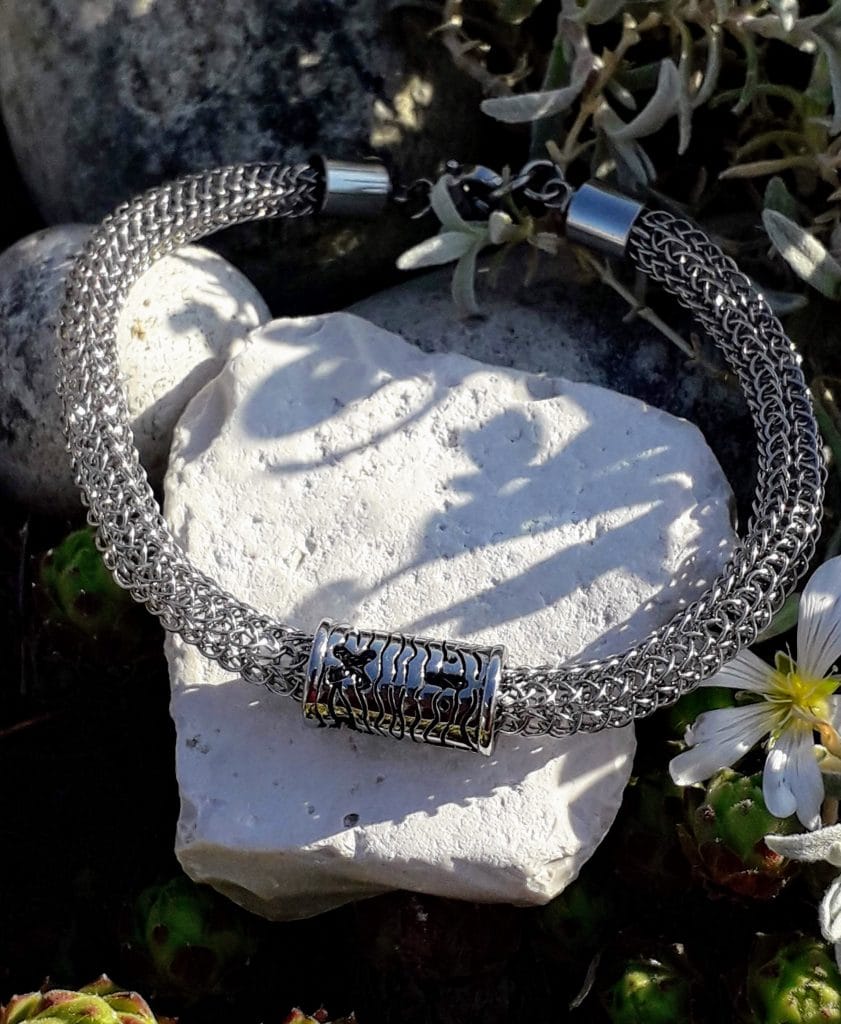 bracelet-Viking-acier-symbole-plus-moins-mcybijoux-nature photographie réalisée à l'extérieur sur une pierre blanche