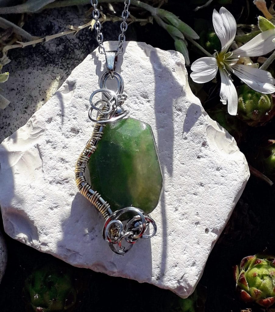 pendentif-agate-mousse-mcybijoux-nature photographie prise à l'extérieur sur une pierre blanche avec une fleur