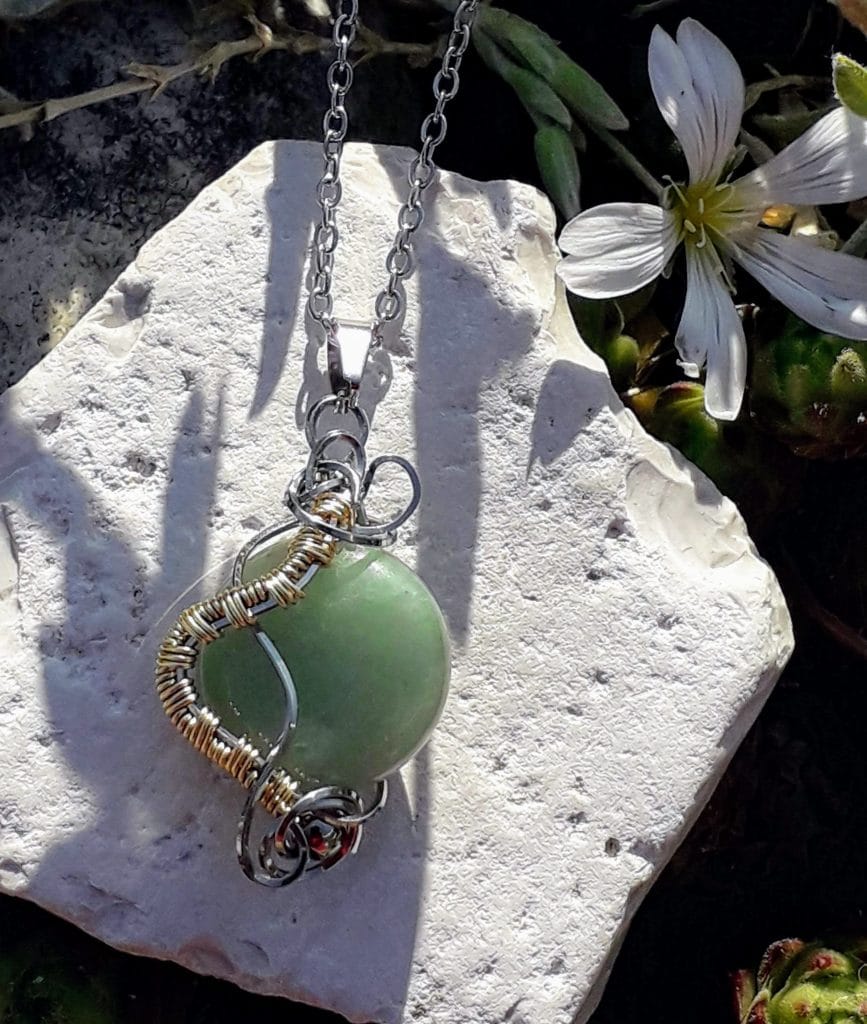 pendentif-aventurine-mcybijoux-nature photographie extérieure sur une pierre blanche avec une fleur