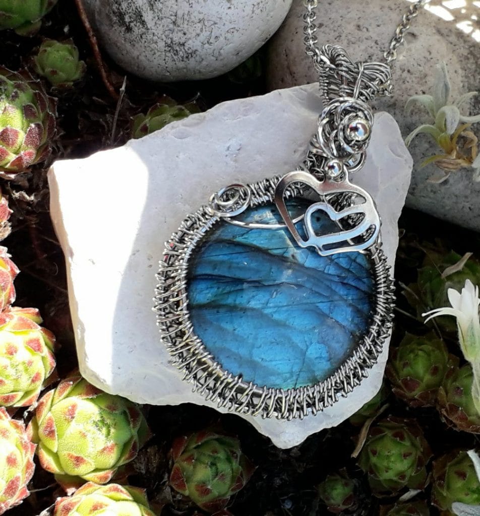 pendentif-labradorite-bleue-mcybijoux-nature photographie prise en extérieur sur une pierre blanche