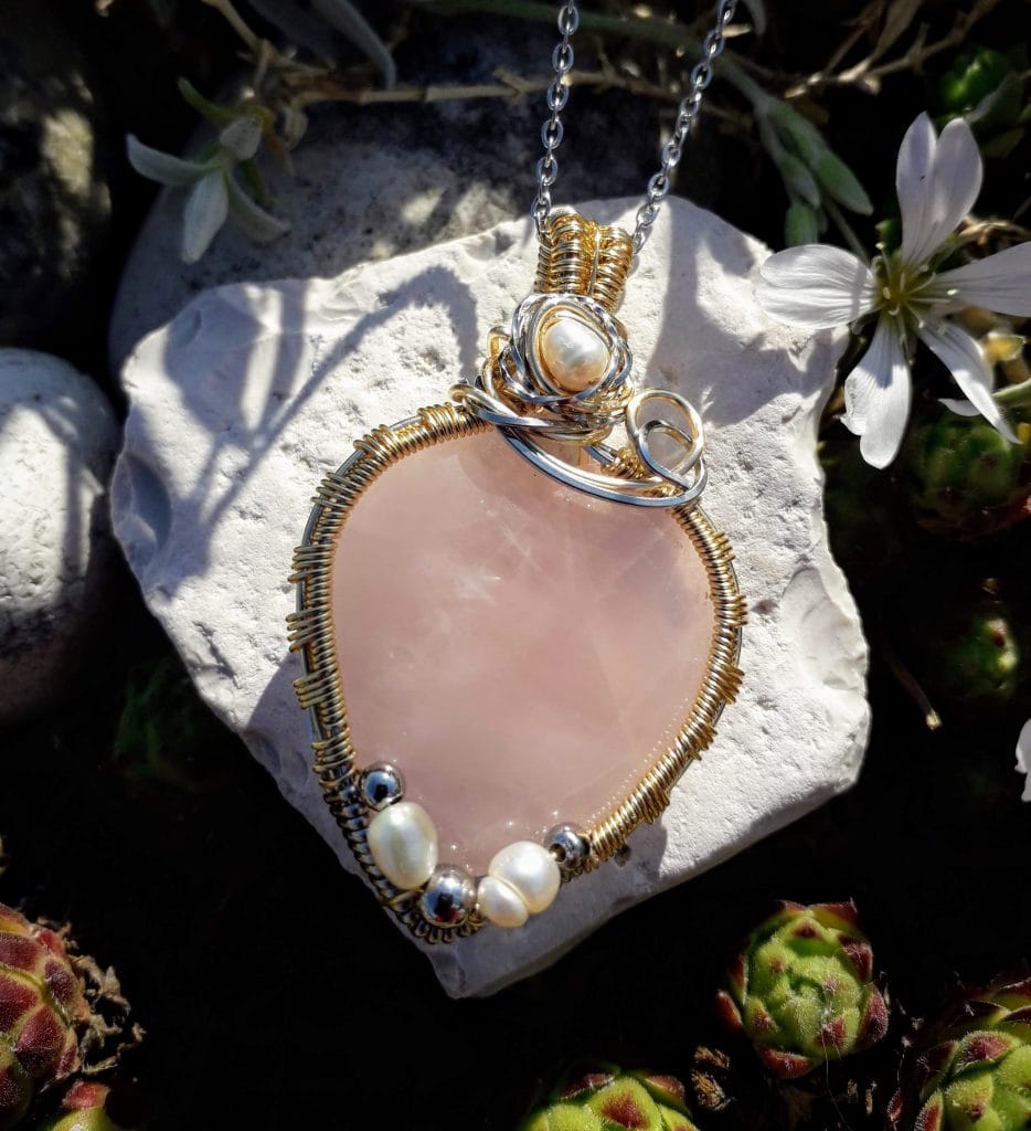 pendentif-quartz-rose-perles-eau-douce-mcybijoux photographie en extérieur une pierre blanche avec une fleur