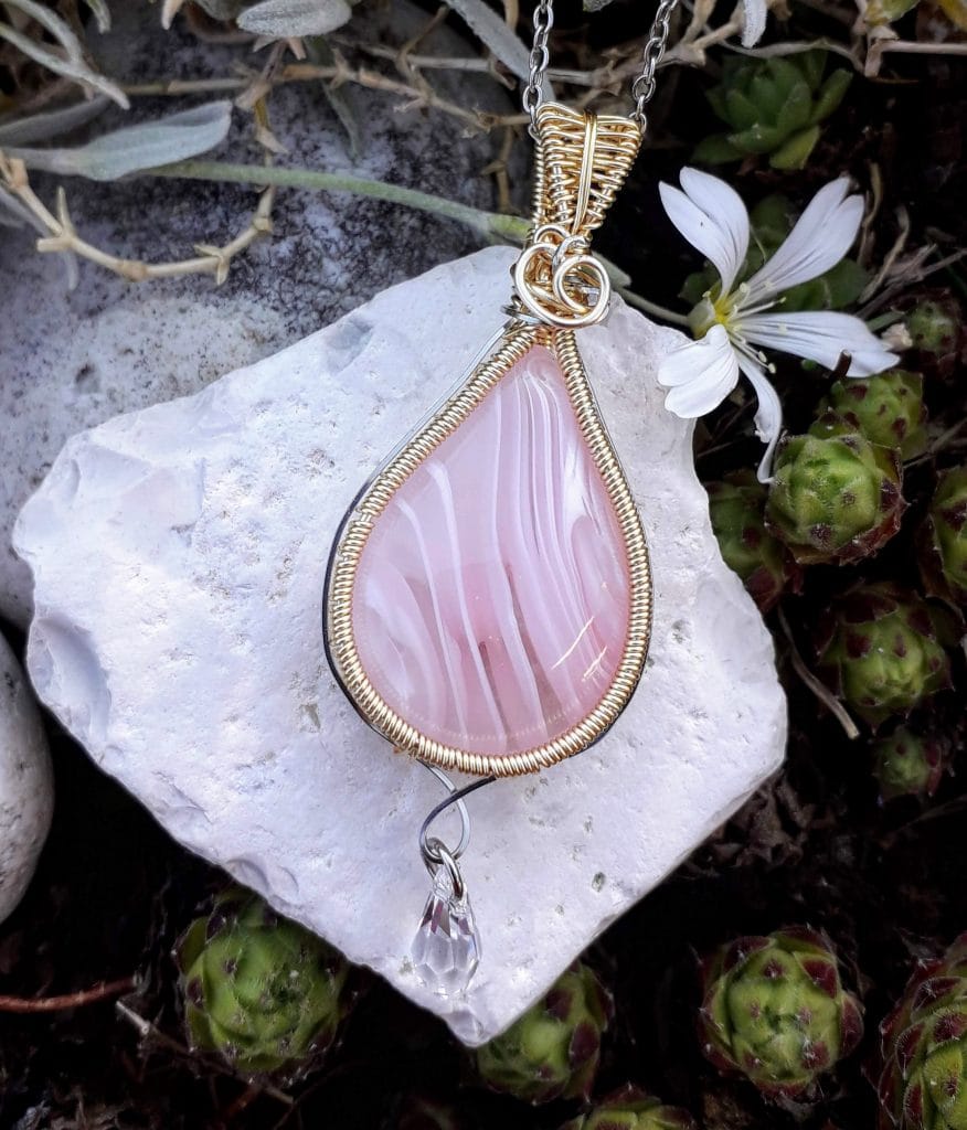 verre-murano-rose-swarovski-mcybijoux photographie prise en extérieur sur une pierre blanche accompagnée d'une fleur