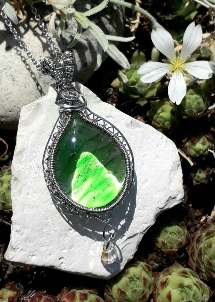 verre-murano- vert-swarovski-mcybijoux photographie en extérieur sur une pierre blanche avec une fleur