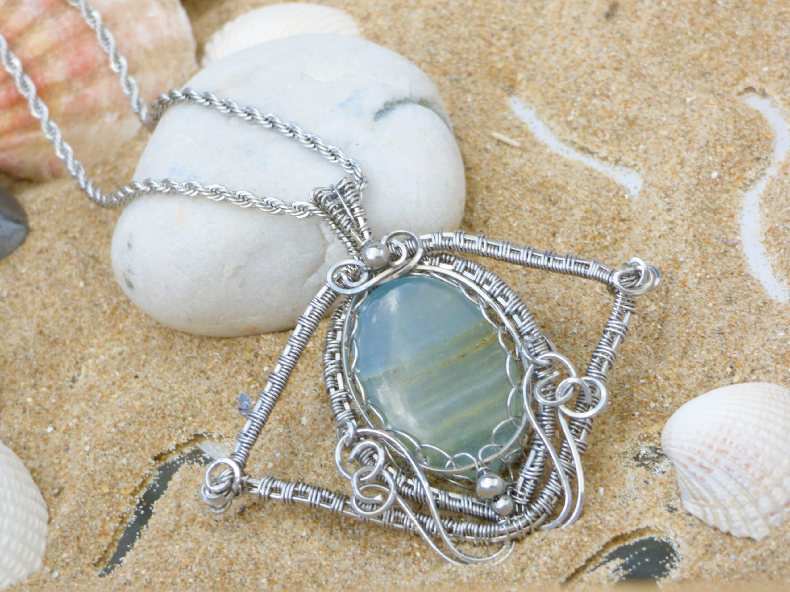 photographie bijou créateur inspiré du bout du monde. Pendentif calcite bleu caraibe tissée au fil acier inoxydable wire wrapping